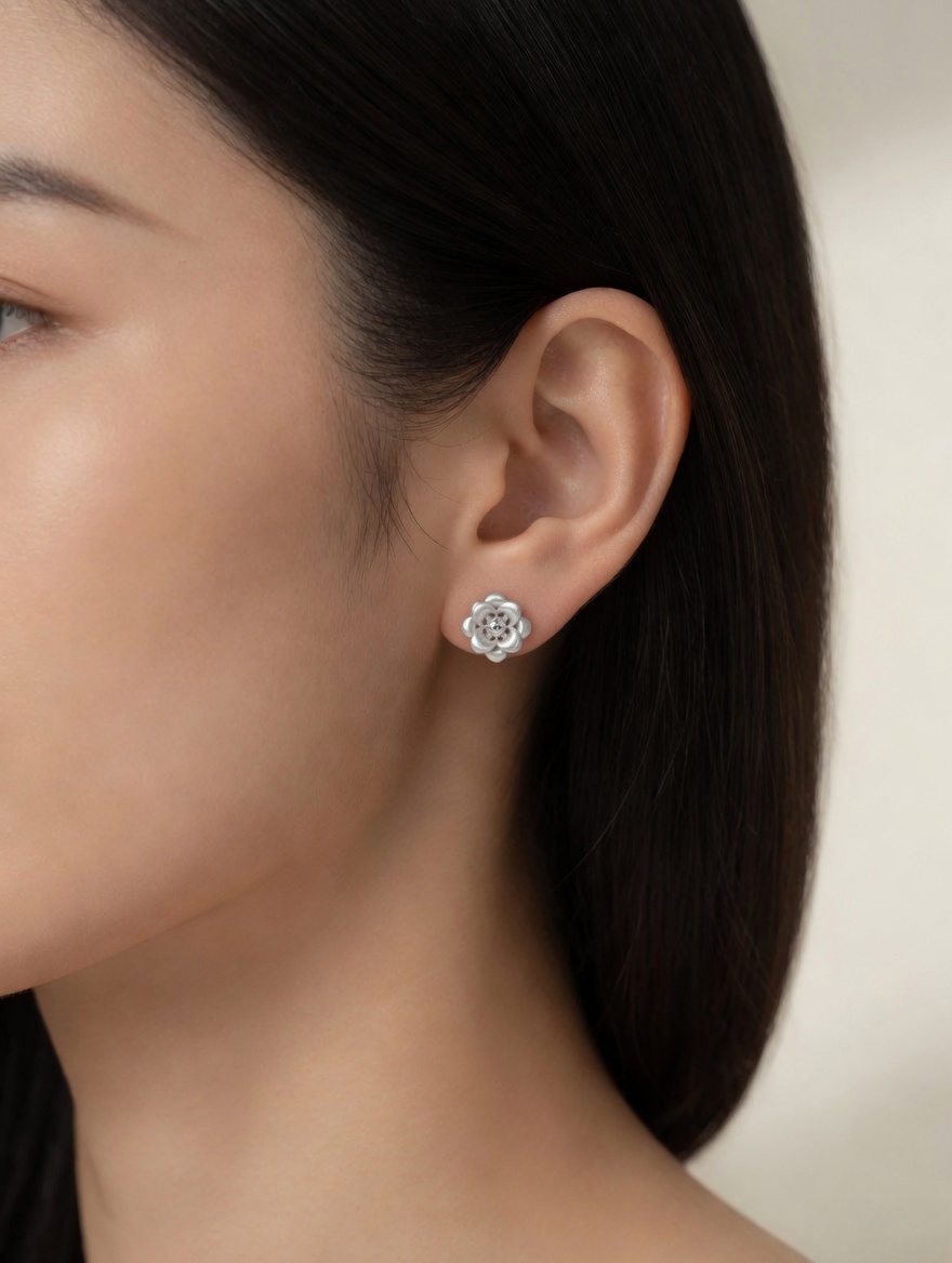 CARV. silver flower stud earrings worn on ear with layered petal design and sculptural floral center
