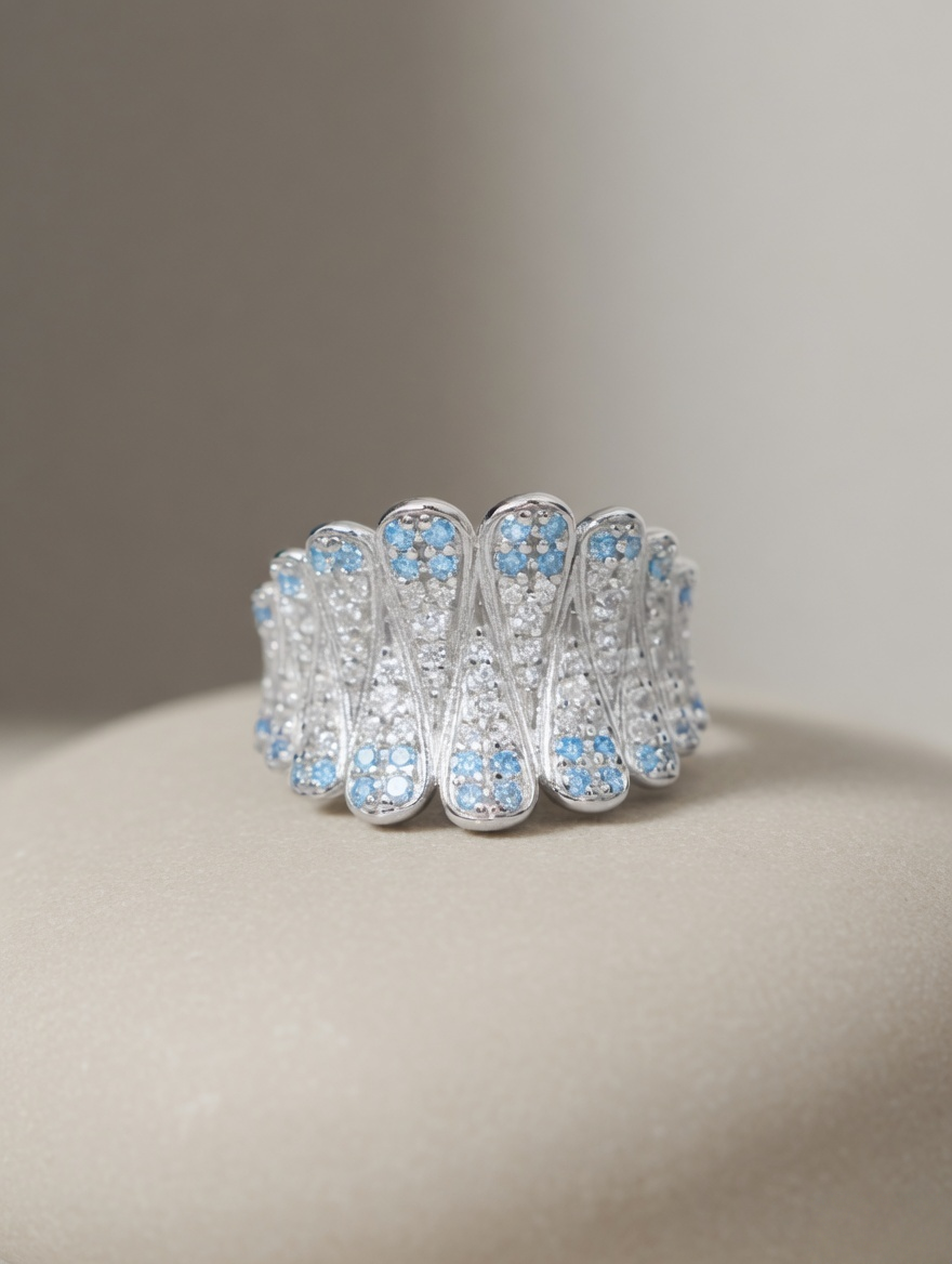 CARV. silver feather statement ring close-up with openwork layers and blue stone accents