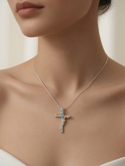 CARV. two-tone cross pendant necklace with blue heart stone and gold leaf accents worn at collarbone