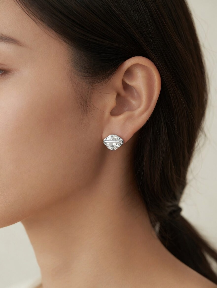 CARV. silver round crystal orbit stud earrings worn on ear with clear crystal and orbit bar detail