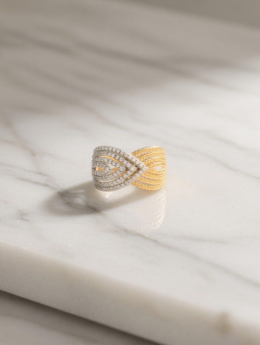 CARV. two-tone pavé crossover ring displayed on stone surface with mixed metal wrap design and pavé detail